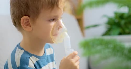 Young Boy Using Nebulizer Mask for Respiratory Treatment