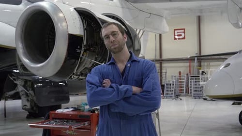 Retrato de un mecánico de aviones masculino seguro de sí mismo en un hangar