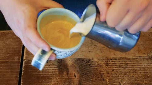 Barista Makes Cappuccino in a Ceramic Mug Pours Milk Into Coffee