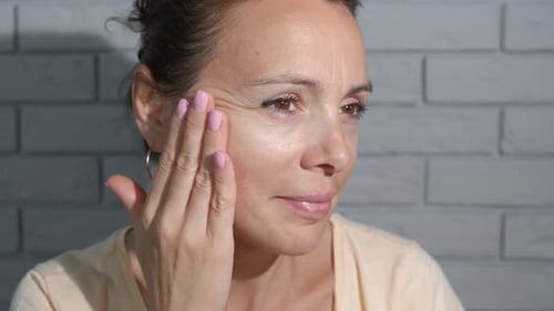 Woman Applying Cream to Her Face
