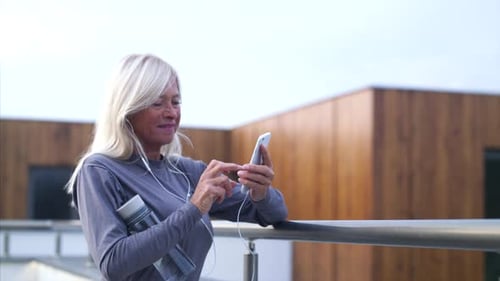 Woman using smart phone outside against modern building