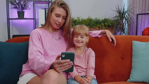 Woman and Child Enjoying Smartphone Together Indoors