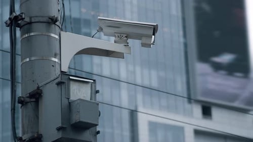 Modern Surveillance Camera Scanning City Street in Urban Background. Futuristic Security Camera