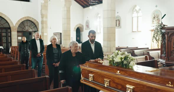 Funeral, iglesia y personas con la mano en el ataúd para despedirse