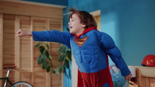 Boy in Superhero Costume Pretends to Fly