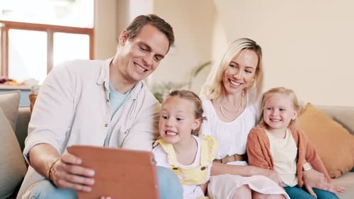 Family Laughing Together at Home Using Tablet