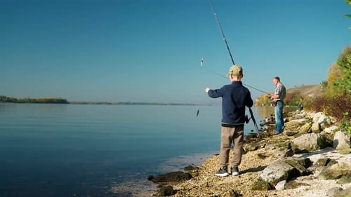 Ein Junge fängt während eines Angelausflugs am Wochenende mit seinem Vater einen kleinen Fisch
