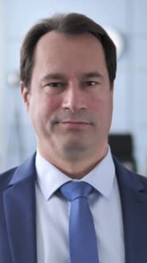 Serious Man in Blue Suit Looks at Camera
