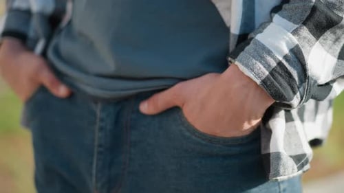 Close Up Person Strolling with Hands in Jean Pockets on Outdoor Pathway