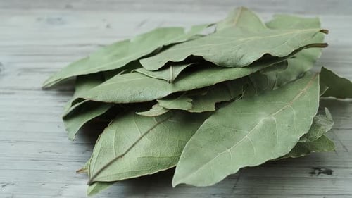 Dried whole bay leaves on cutting board (Laurus nobilis)