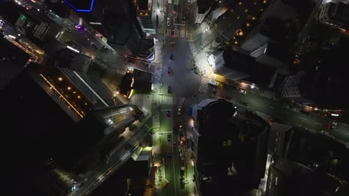 Vue du haut vers le bas de véhicules traversant un carrefour routier dans un quartier urbain de Night City Tokyo