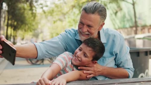 Grandfather and Boy Smiling for Selfie Outside