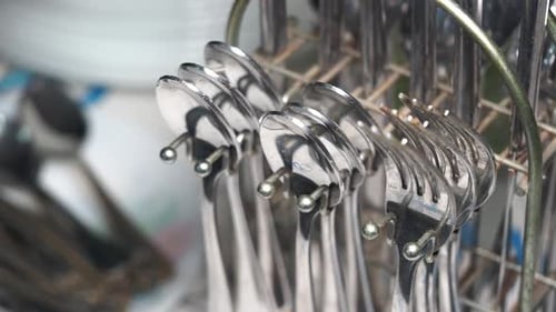 Tenedores en una rejilla de secado después de lavarlos en una cocina concurrida
