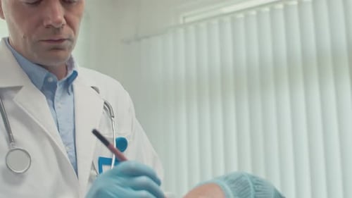 Plastic Surgeon Marking Skin of Young Woman during Facelift Procedure