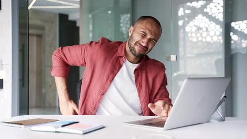 Man Working on Laptop Experiences Back Pain