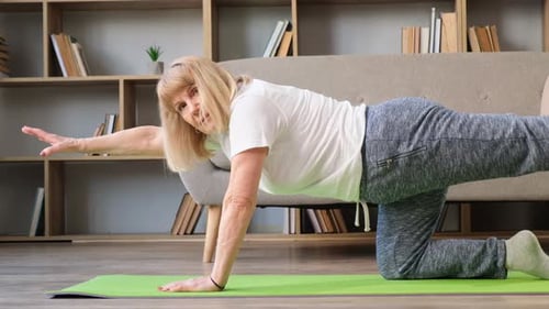 Senior Woman Exercising on Yoga Mat at Home