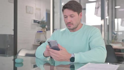 Gelegenheitsmann, der mit Smartphone und E-Mail beschäftigt ist