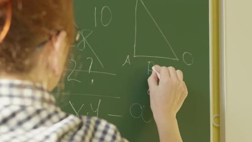 A Girl Student Writes on a Green Board