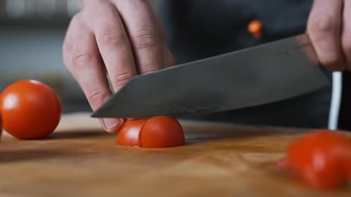 Chef slowly slicing a tomato with a large sharp knife,vegetables.