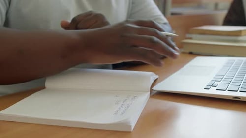 Unrecognizable Black Man Studying In College