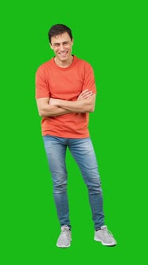 Fröhlicher Mann steht im Studio auf grünem Hintergrund