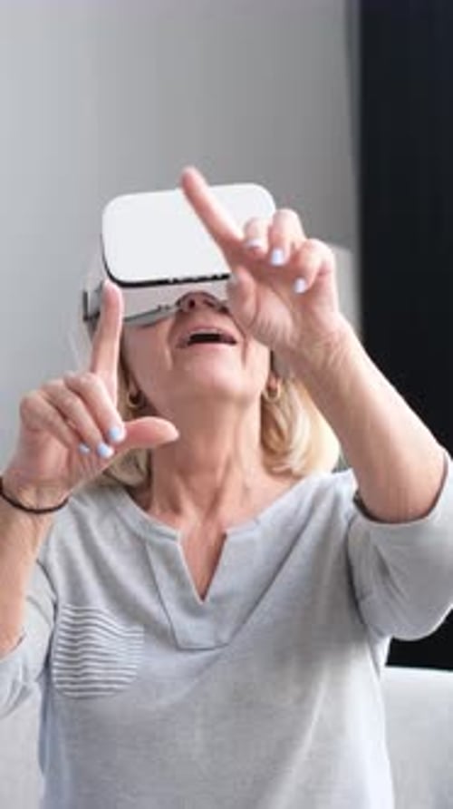 Excited Senior Woman Using Virtual Reality Headset at Home