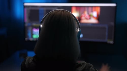 Back View of Unrecognizable Video Editor in Headset Working From Home at Digital Project Sitting in
