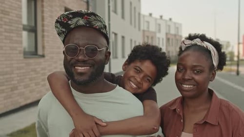 Portrait of Happy Black Family of Three Outdoors