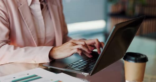 Woman Typing on Laptop in Office Setting