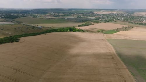 aerial view over wheat field with shadow of clouds moving over it