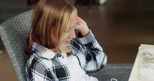 Teenage Girl Relaxing in a Chair Indoors