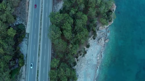 The Camera Flies Over the Road Located on the Seashore in the Evening