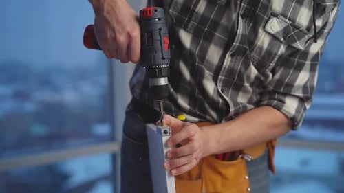 Torso Shot of Person Drilling Metal Frame