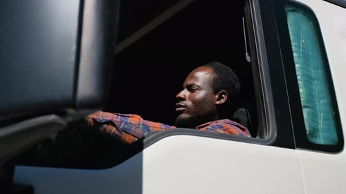 African American Truck Driver Sitting in Cab