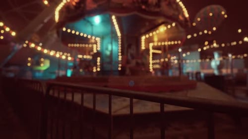 Empty Amusement Park at Night Showcasing a Deserted Carousel and Dim Lights