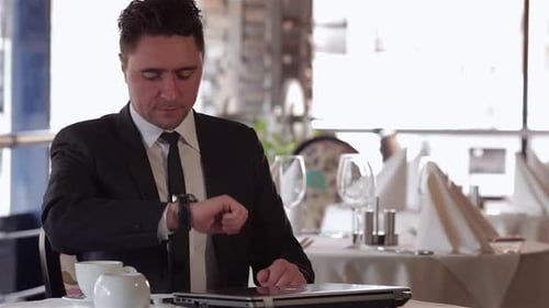 Man in Suit Waiting at Restaurant Table