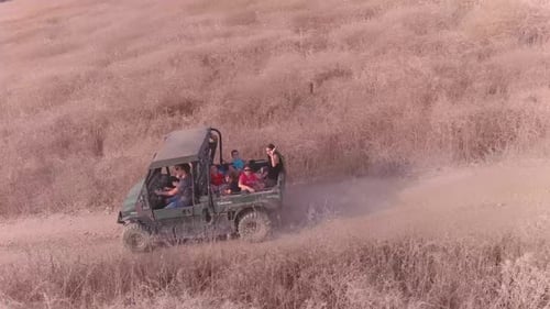 Large family driving offroad, kids riding in the back of a pickup truck