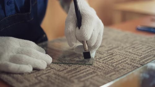 Glass Cutter Scoring Glass Sheet in Workshop