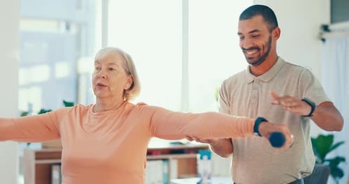 Senior Woman Lifting Dumbbells with Young Adult Trainer
