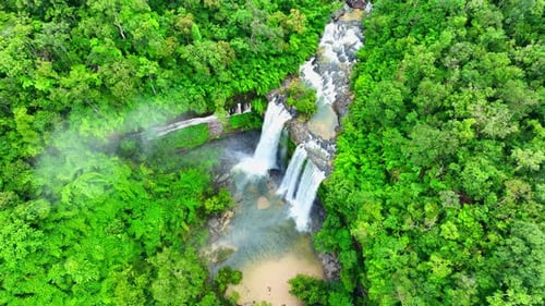Aerial view over a waterfall in a beautiful tropical forest.
