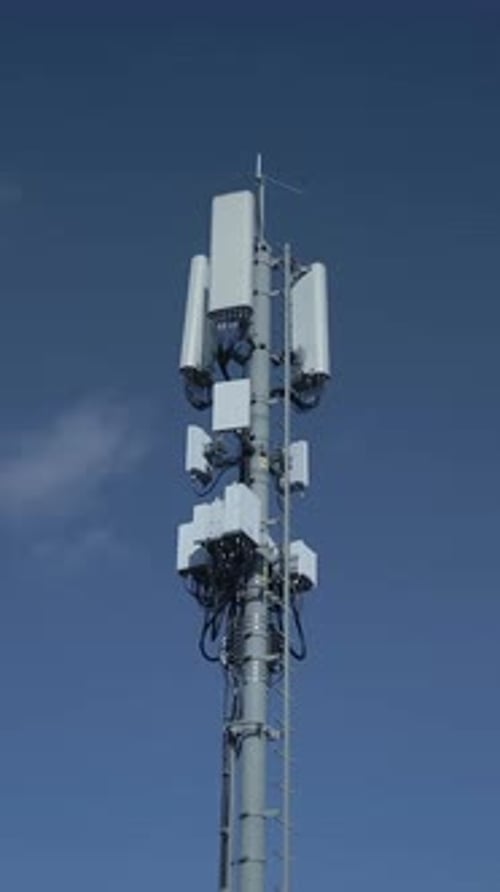 A Telecommunications Tower Equipped with Various Antennas Set Against a Clear Blue Sky
