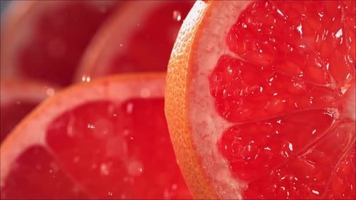 Drop of Grapefruit Juice Flows Down the Surface of a Ripe Juicy Grapefruit Slice