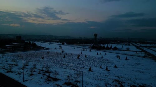 At sunset, a drone flying with crows over the road