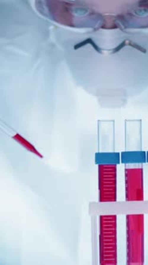 Scientist Drops Liquid in Lab Test Tubes