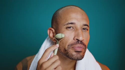 Man Massaging His Face with Jade Facial Roller