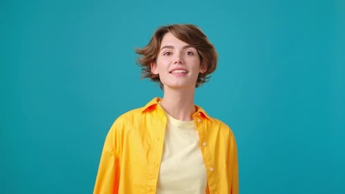 Smiling Woman Waving Hello in Studio Setting
