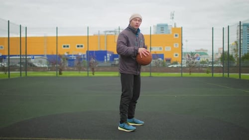 Man Practices Basketball Dribbling Skills on Outdoor Court