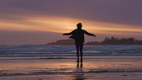 Adventurous Woman Standing on the Sandy Beach on the West Coast of Pacific Ocean