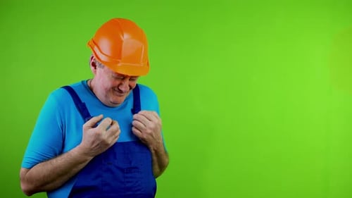Man in Overalls and Hard Hat Looking Distressed