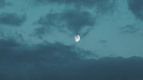 Gibbous Moon Shines Through Billowing Cloudy Night Sky